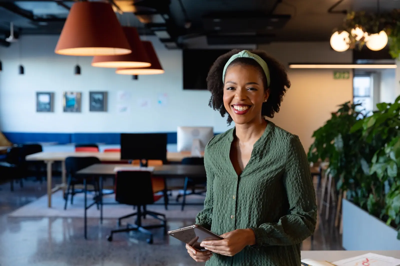 Smiling professional with tablet in modern office